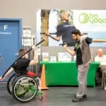 Adaptive Bo Yoga instructor Nate helping Jaya stretch at the Discover Conference